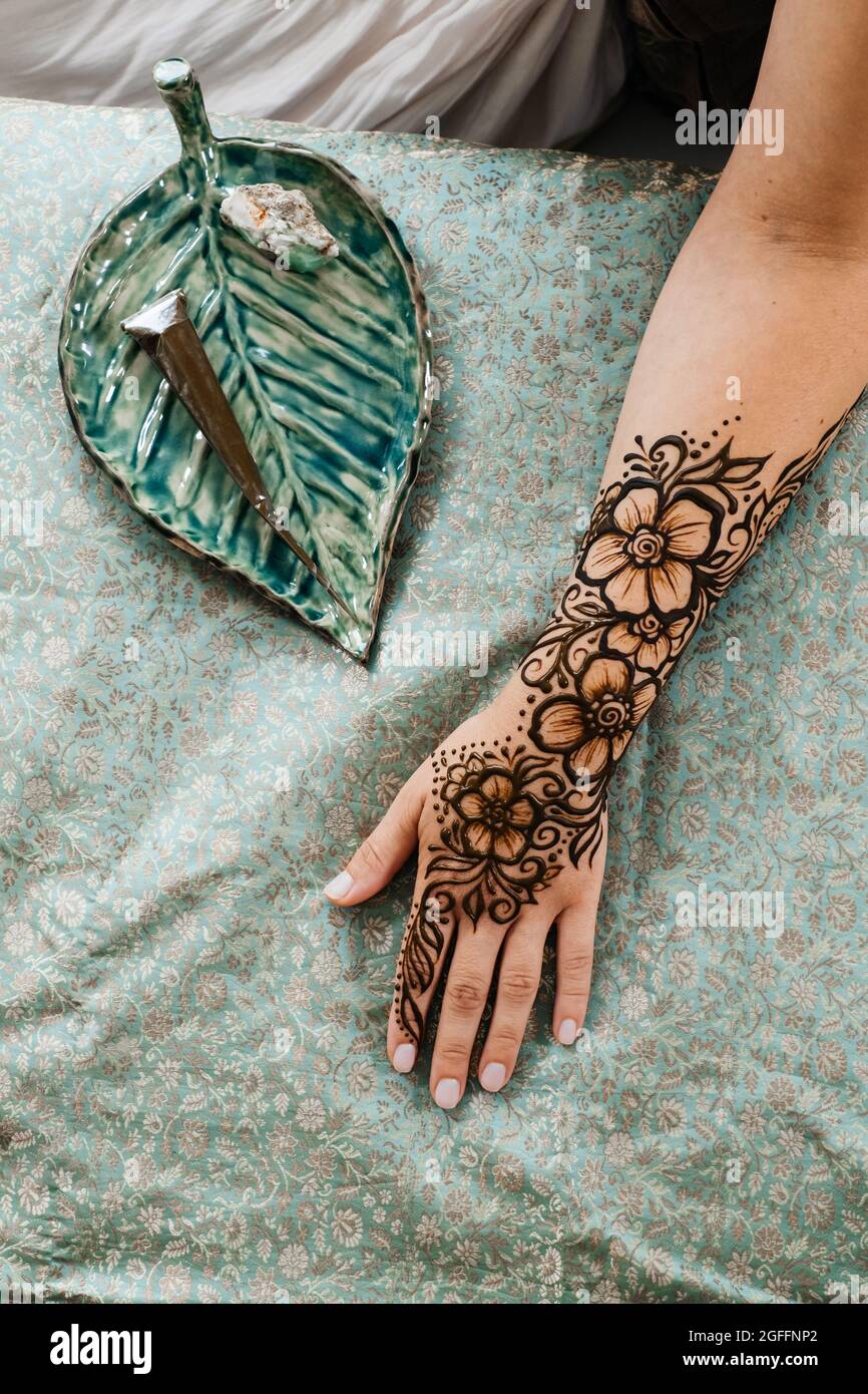 Top view art henné tatuaggio su mani femminili. Master artista che disegna mehndi arabo per sposa prima del matrimonio. Primo piano, vista dall'alto. Design floreale. Cono Foto Stock