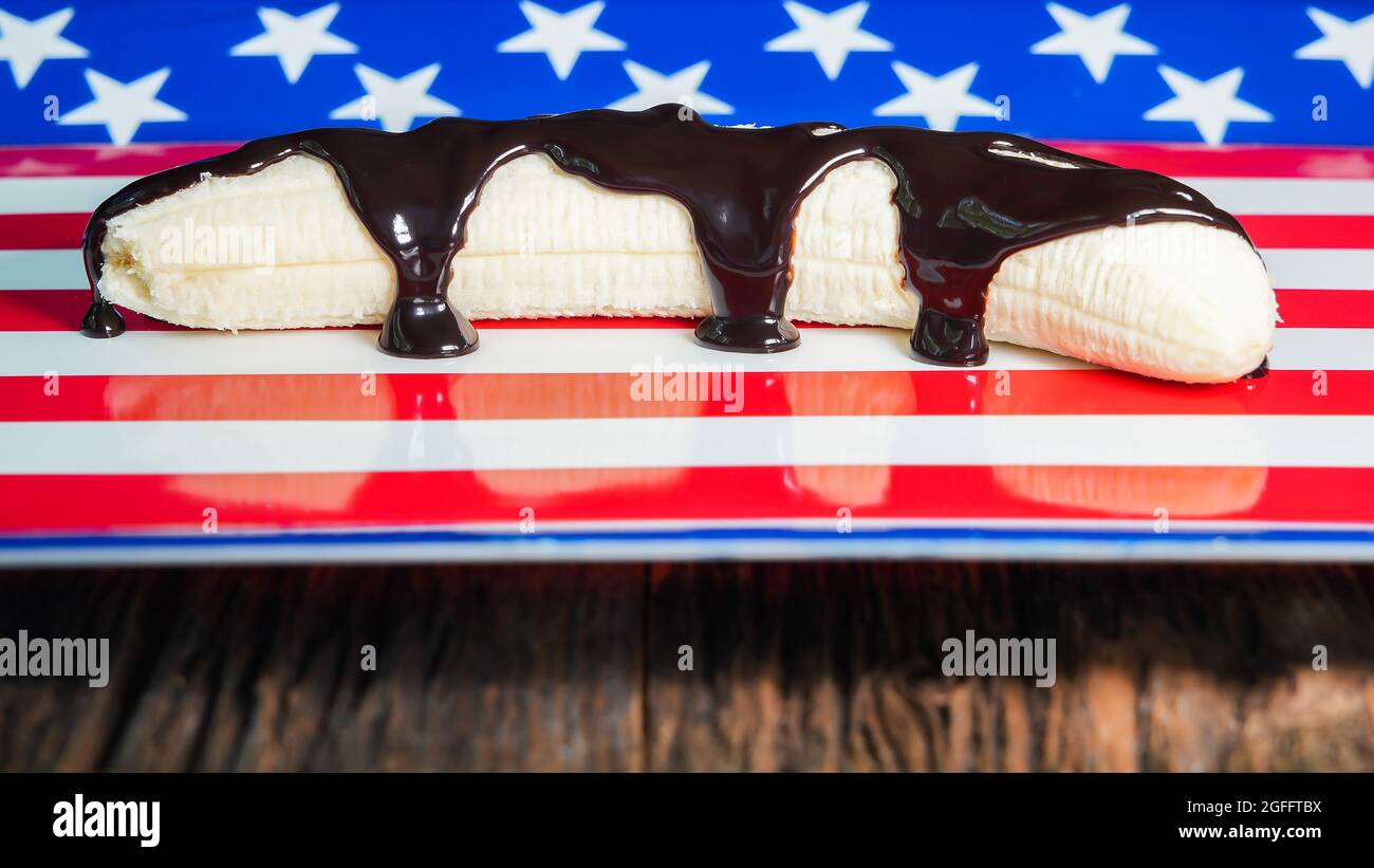Banana con cioccolato fondente sullo sfondo della bandiera americana Foto Stock