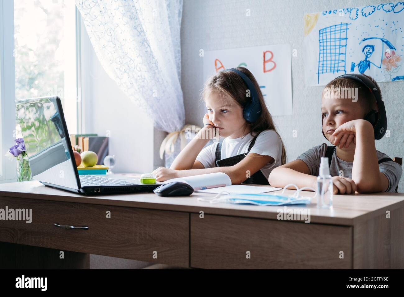Schoolkids ragazzo e ragazza utilizzando il portatile per lo studio online durante la homeschooling a casa. Homeschooling, studio in linea, apprendimento in linea della quarantena domestica Foto Stock