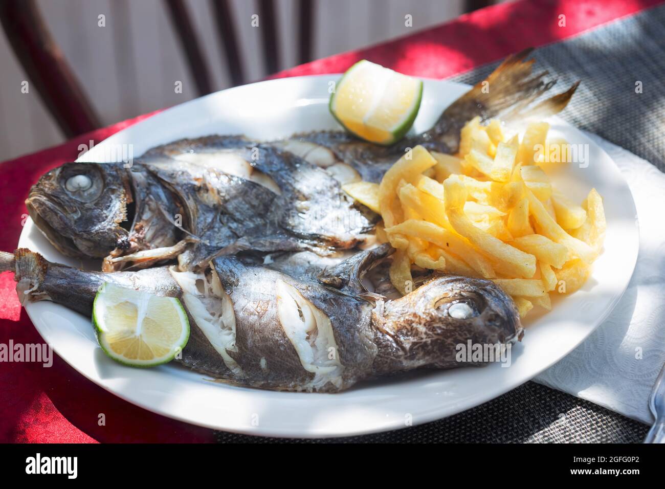 Pesce alla griglia con patatine fritte e lime, ristorante, Essaouira, Marocco Foto Stock