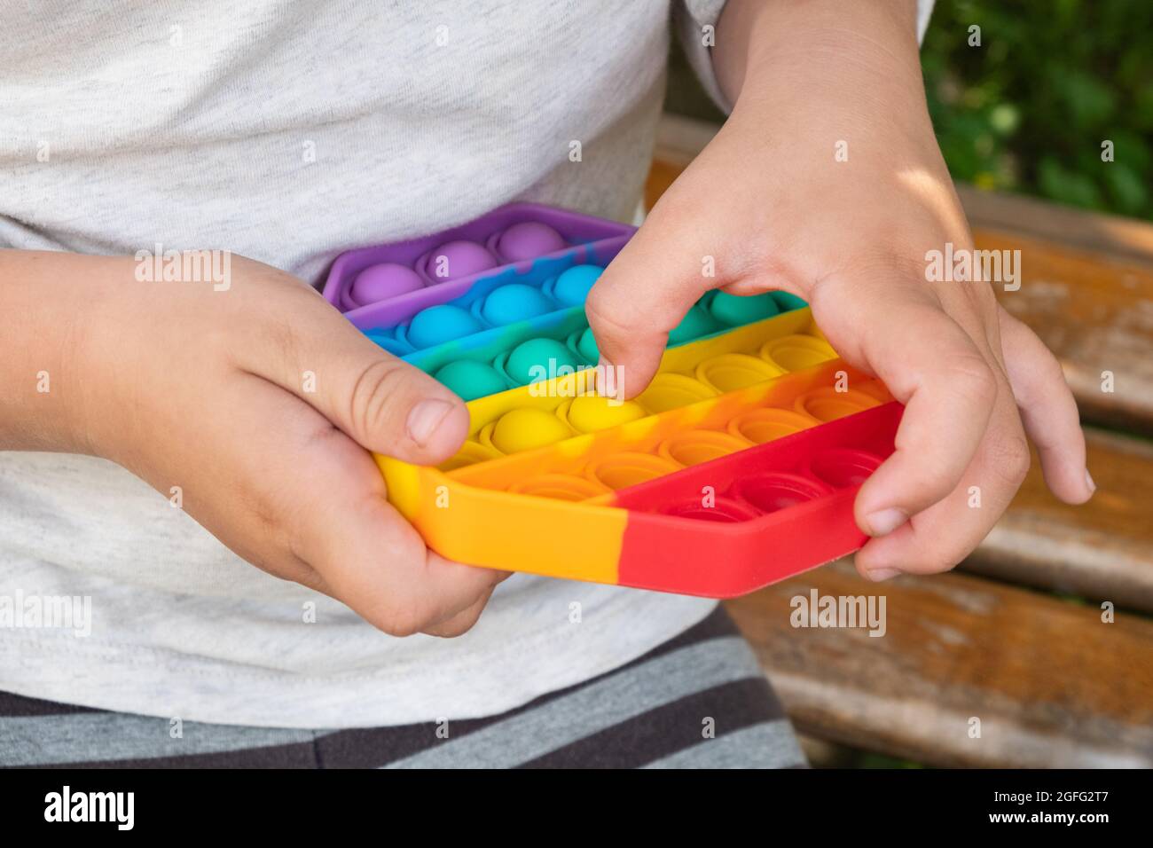 bambino che gioca con colorato giocattolo educativo semplice concavità. Foto Stock