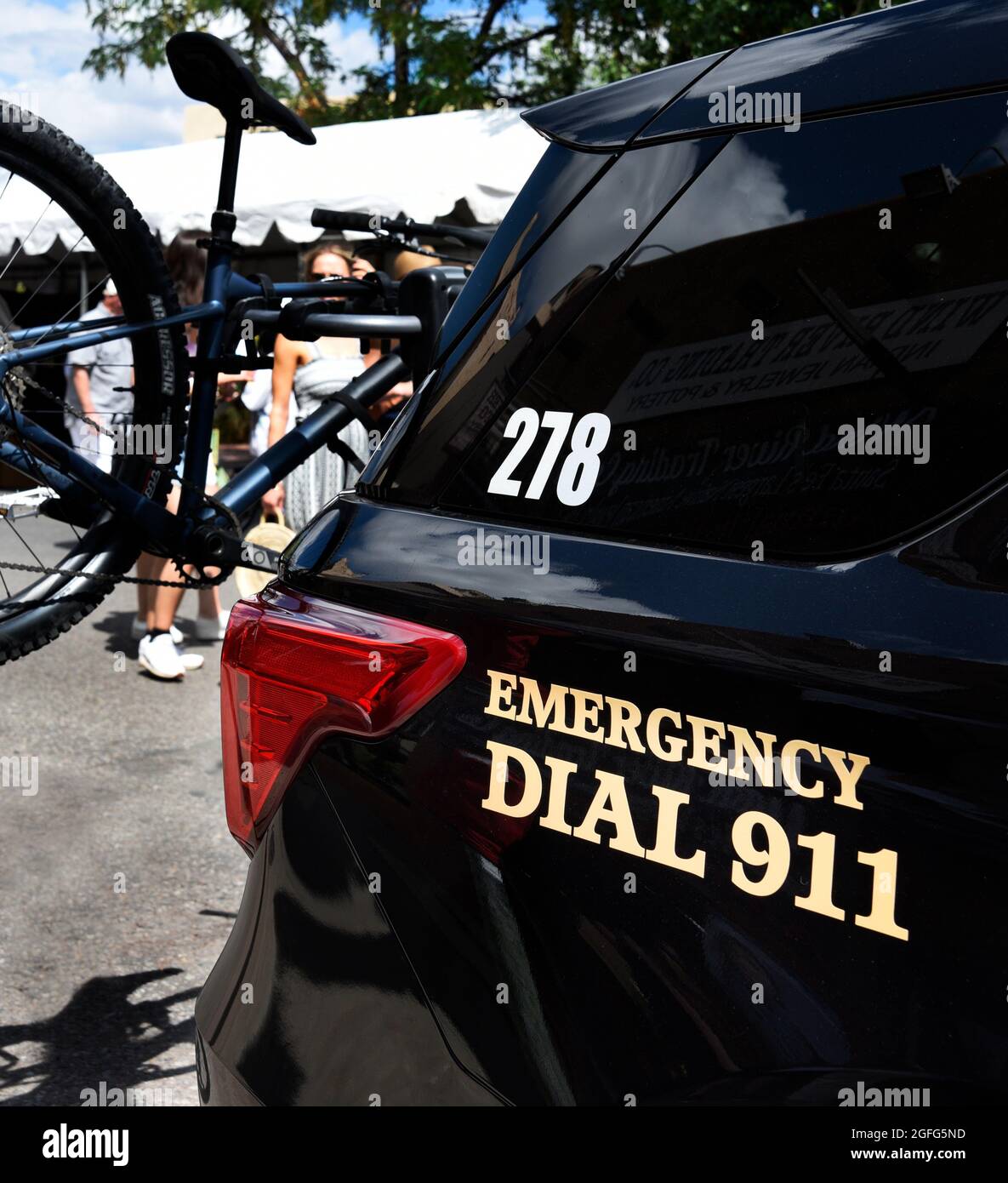 Un'auto della polizia con chiamata di emergenza 911 parcheggiata in una mostra d'arte all'aperto a Santa Fe, New Mexico. Foto Stock