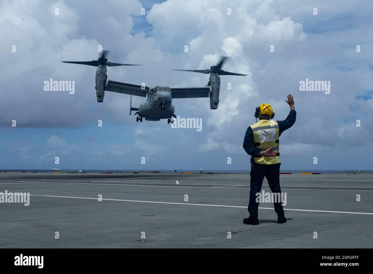 Un Navy Sailor britannico dirige un MV-22 Osprey durante le esercitazioni touch-and-go a bordo della HMS Queen Elizabeth nel Mare delle Filippine, 21 agosto 2021. La formazione cross-deck con alleati e partner migliora la nostra capacità di lavorare insieme e rimanere tatticamente competente. Il 31 MEU opera a bordo di navi dell'America Expeditionary Strike Group nella settima area di attività della flotta per migliorare l'interoperabilità con gli alleati e i partner e fungere da pronta forza di reazione per difendere la pace e la stabilità nella regione IndoPacifico. (STATI UNITI Foto del corpo marino di CPL. Alessandria Nowell) Foto Stock