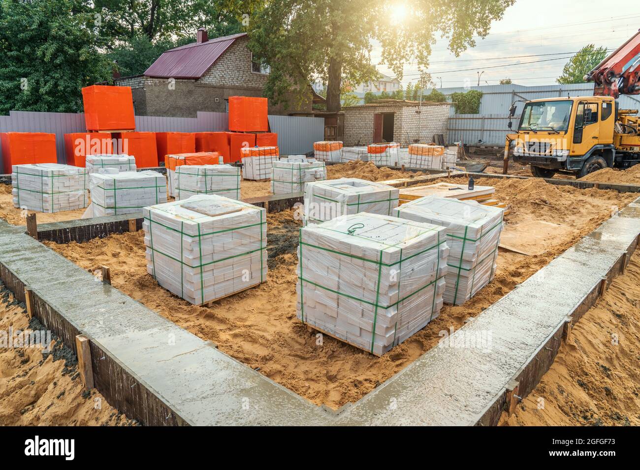 Fondazione striscia appena versata in cantiere e materiali da costruzione per la costruzione di nuova casa. Foto Stock