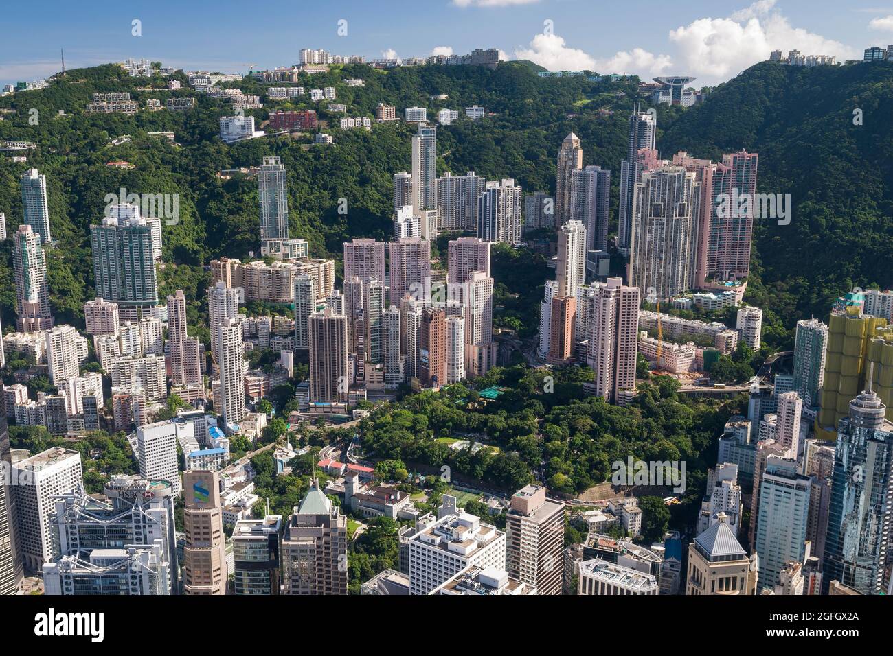 Gli alti blocchi di appartamenti residenziali di Mid-level e case di lusso sul Peak sopra gli edifici commerciali di Central, Hong Kong Island Foto Stock