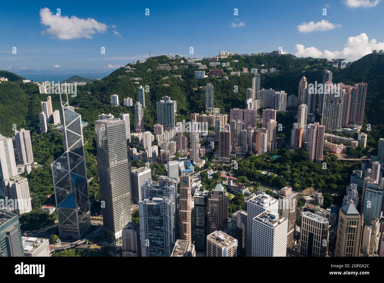 Gli alti blocchi di appartamenti residenziali di Mid-level e case di lusso sul Peak dietro gli edifici commerciali di Central, Hong Kong Island Foto Stock