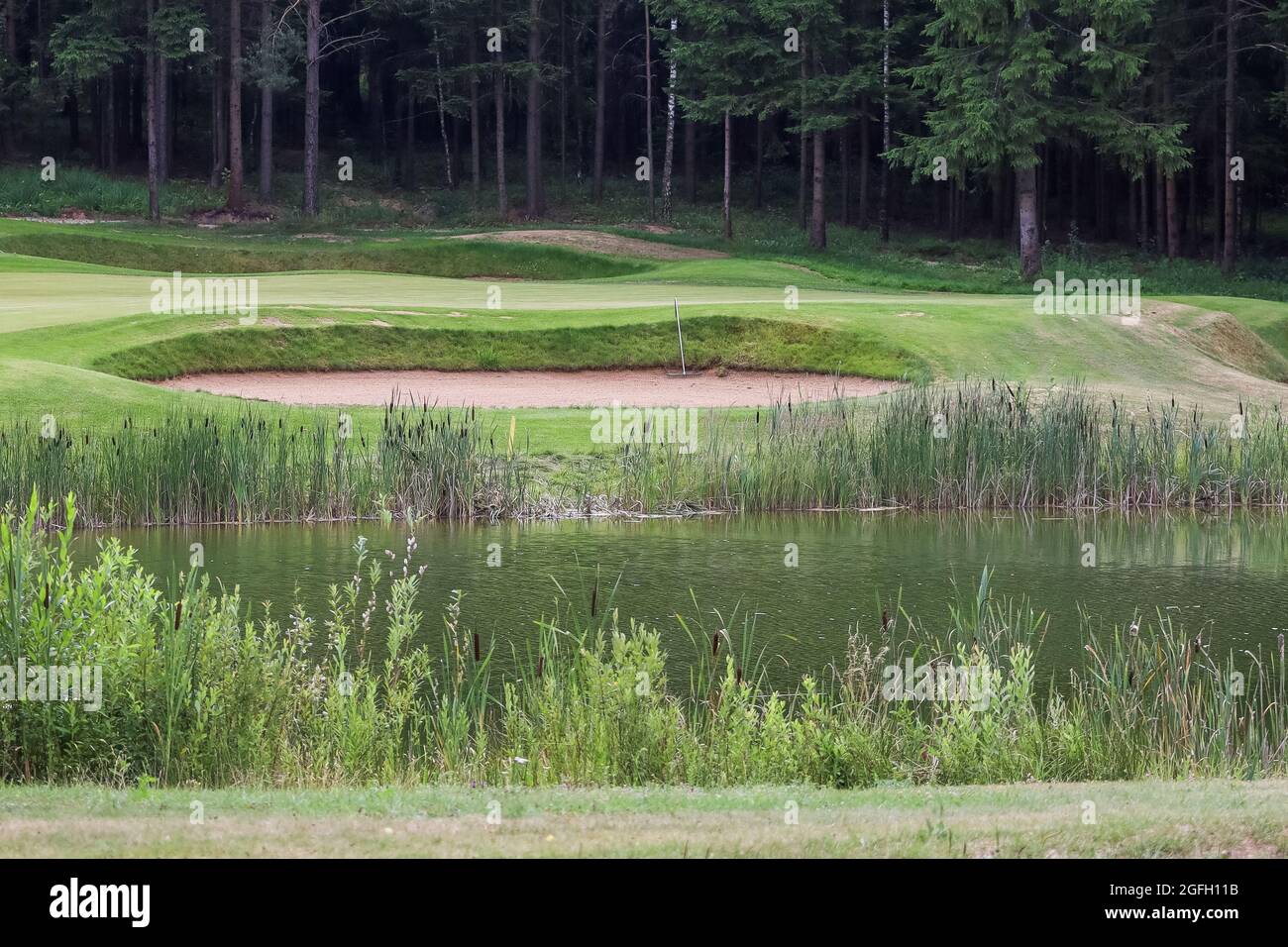 Lago circondato dal verde sul territorio del golf club. Serbatoio artificiale. Foto Stock