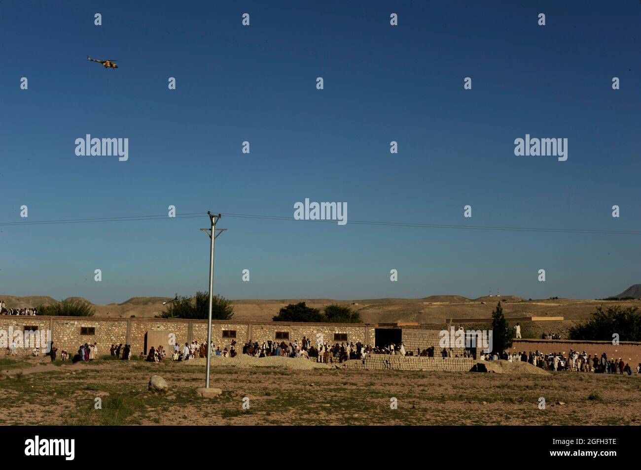 Gli afghani osservano le scatole delle urne elettorali caricate su un elicottero MI-17 vicino a Kabul, Afghanistan, 21 settembre 2010. (STATI UNITI Air Force Photo/staff Sgt. Eric Harris) (RILASCIATO) Foto Stock