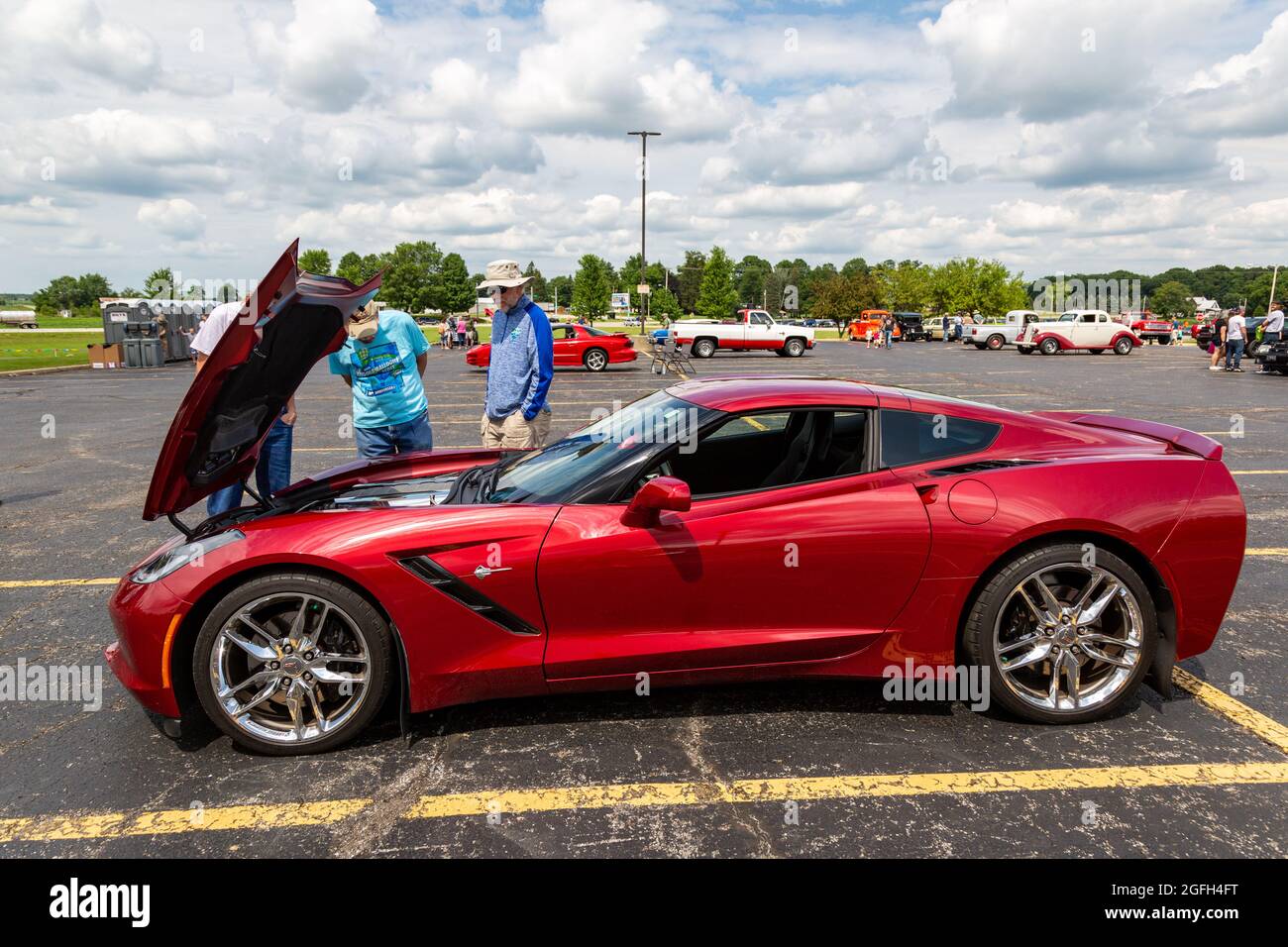 Gli ammiratori ispezionano una vettura sportiva rossa C7 Chevrolet Corvette Stingray in esposizione in Angola, Indiana, USA. Foto Stock