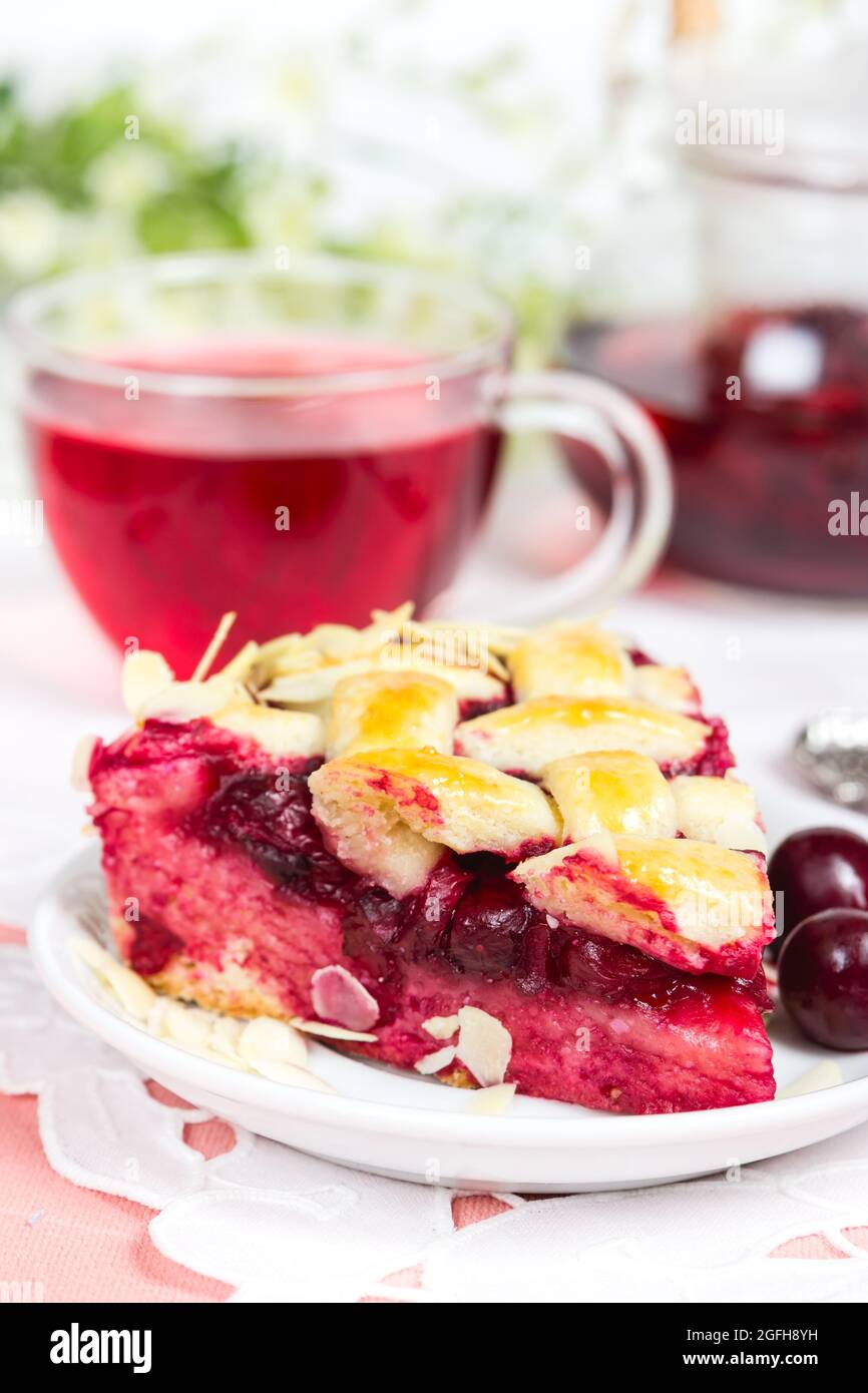 Torta di ciliegie con reticolo e tazza di tè karkade Foto Stock