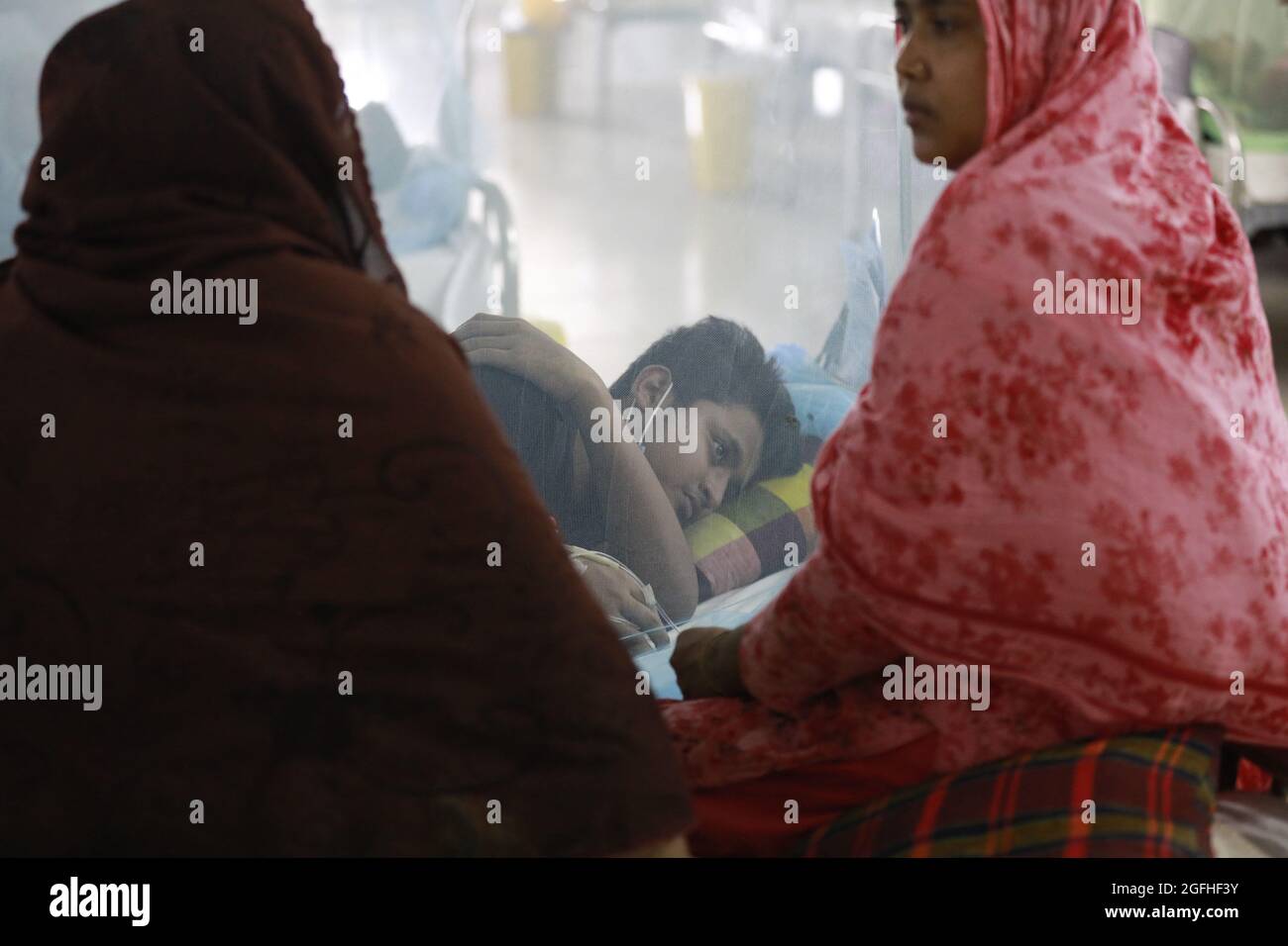 Dhaka, Bangladesh. 25 ago 2021. Un uomo coperto da una zanzariera è trattato per dengue al Sir Salimullah Medical College Hospital a Dhaka, Bangladesh, 25 agosto 2021. Il bilancio delle vittime della dengue ha raggiunto 38 con un altro decesso nelle 24 ore fino a martedì, ha detto un rapporto della direzione generale dei servizi sanitari (DGHS). L'epidemia di dengue è diventata una causa di grande preoccupazione in quanto il paese sta combattendo la variante Delta più mortale del coronavirus con le sue limitate strutture sanitarie negli ultimi mesi. Photo by Suvra Kanti Das/ABACAPRESS.COM Credit: Abaca Press/Alamy Live News Foto Stock