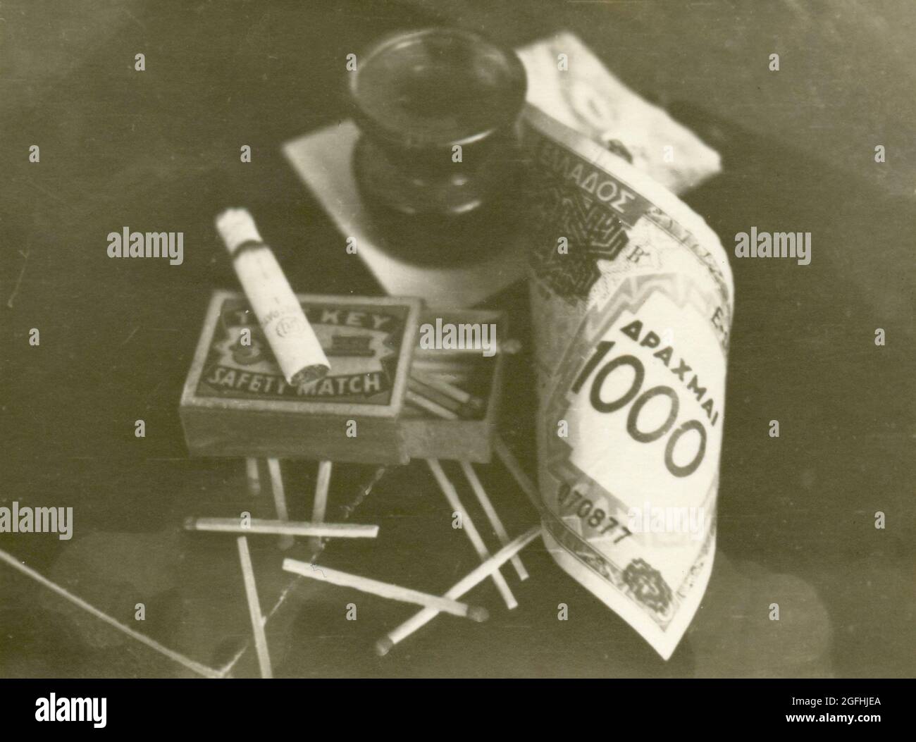 Conposizione con il denaro greco Drachma, partite, sigarette, e inkwell, 1940 Foto Stock
