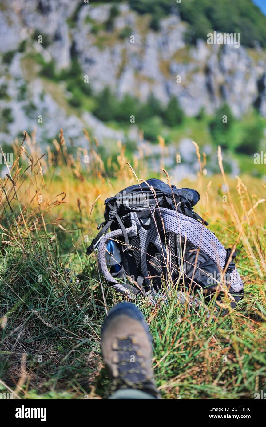 Primo piano di scarpe da trekking e zaino nella valle di montagna Foto Stock