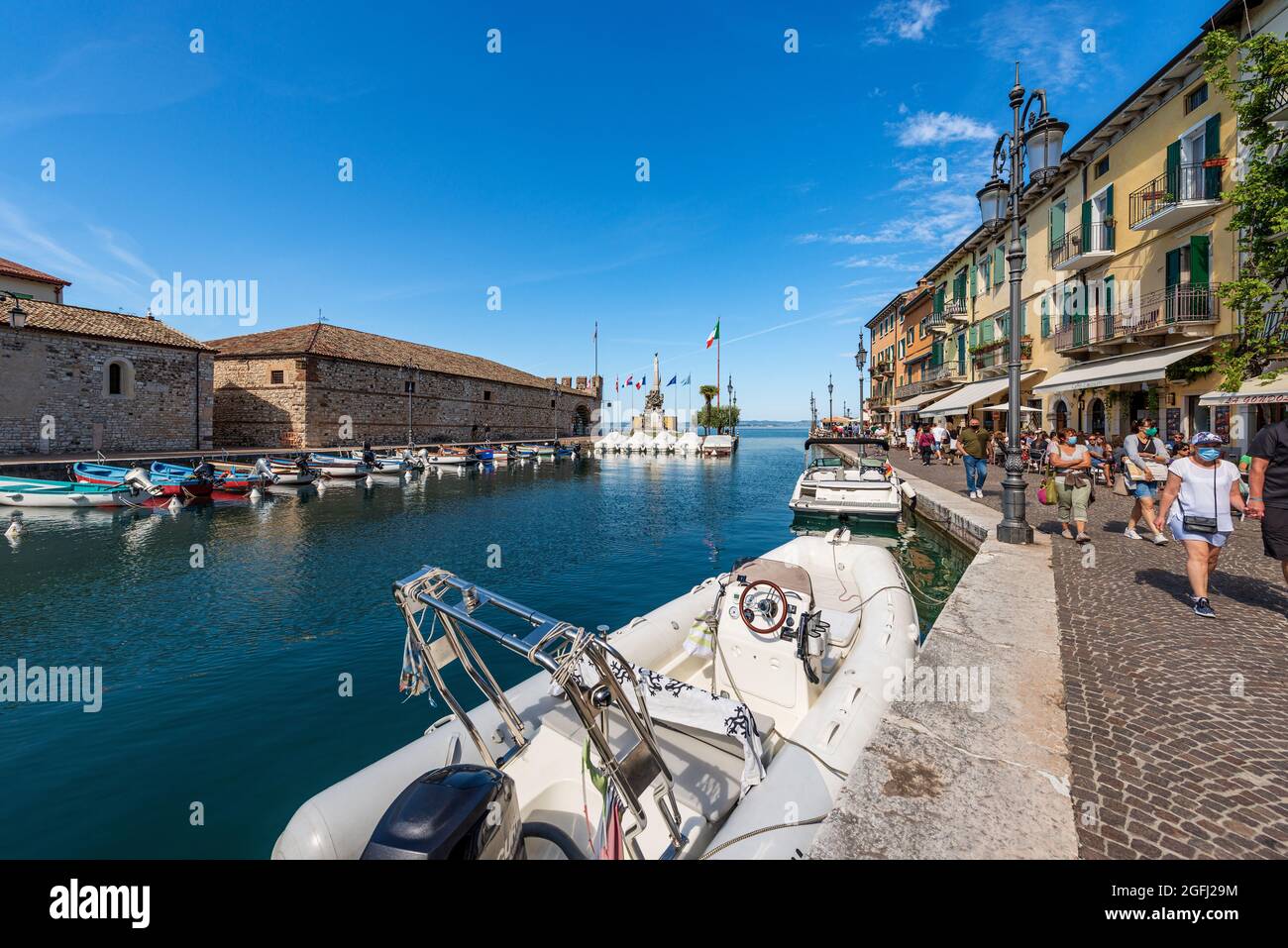 Piccolo porto del villaggio di Lazise con barche ormeggiate. Località turistica sulla costa del Lago di Garda (Lago di Garda). Verona provincia, Veneto, Italia, Europa. Foto Stock