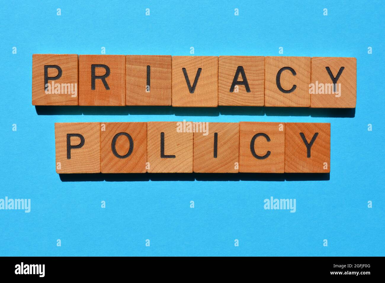 Privacy Policy, parole in lettere di legno isolate su sfondo blu Foto Stock