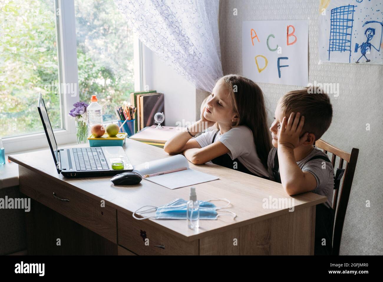 Schoolkids ragazzo e ragazza utilizzando il portatile per lo studio online durante la homeschooling a casa. Homeschooling, studio in linea, apprendimento in linea della quarantena domestica Foto Stock