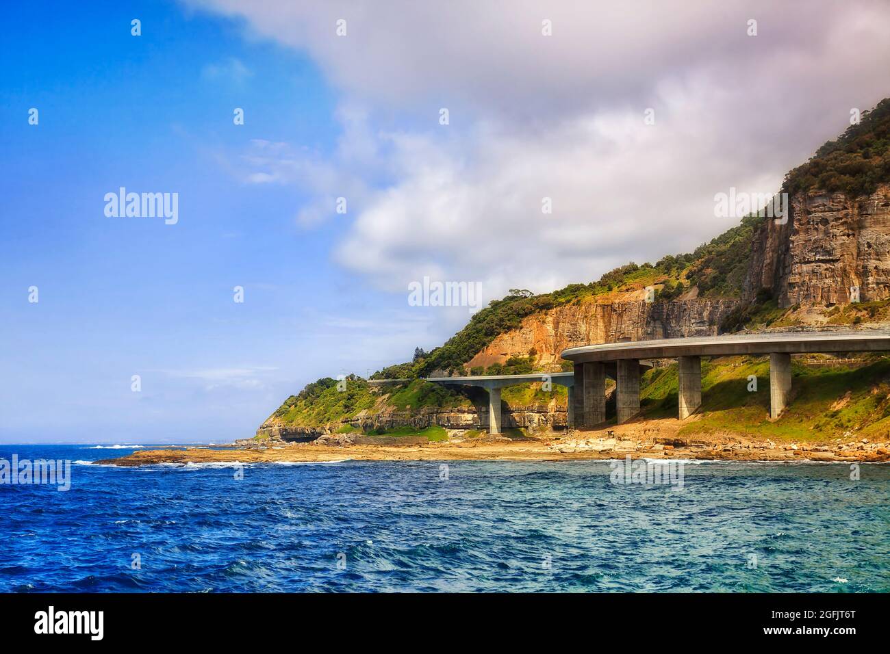 Il Grand Pacific Drive Sea Cliff Bridge intorno alle rocce di arenaria sulla costa pacifica dell'Australia. Foto Stock