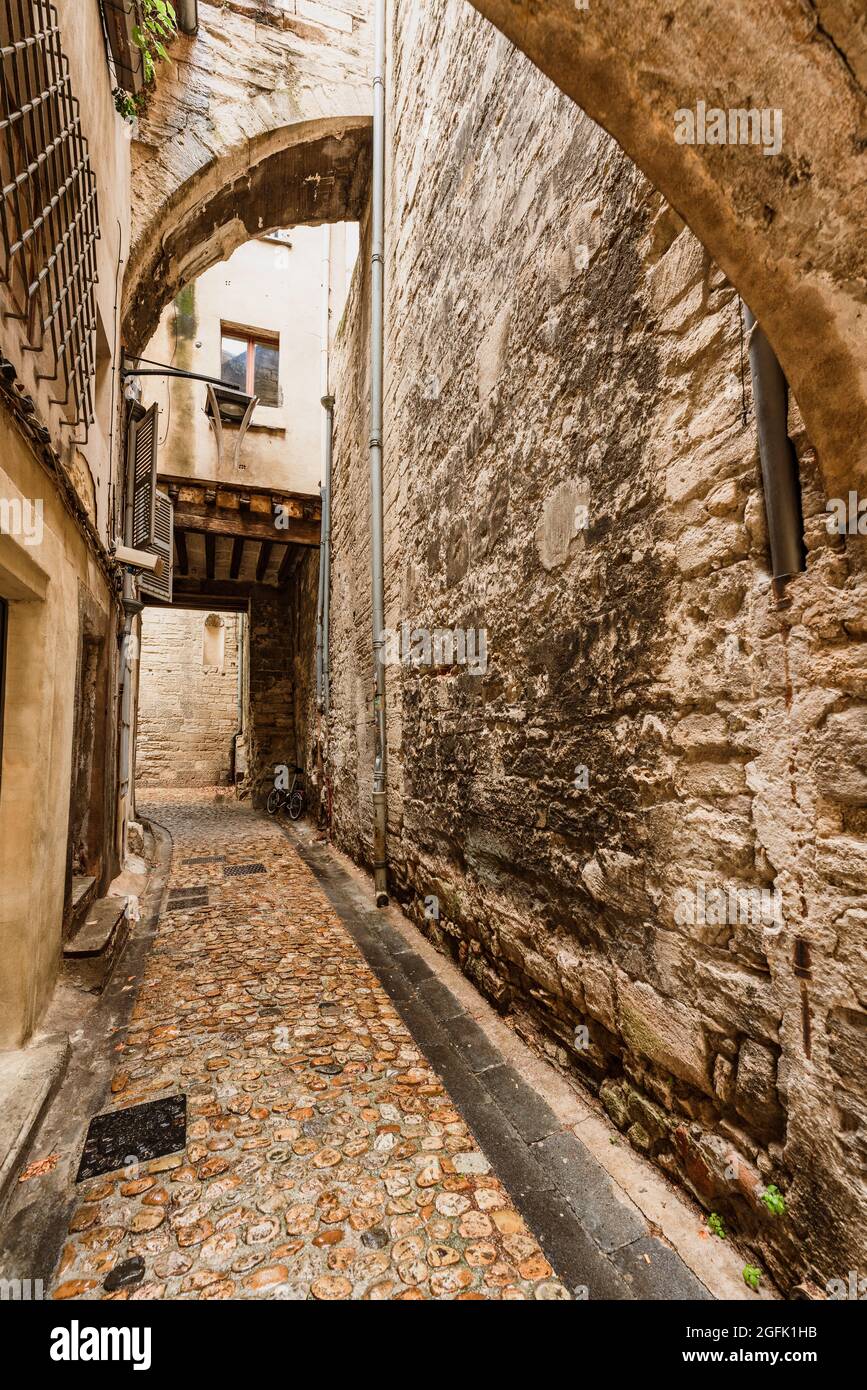Vicolo stretto coperto con archi in pietra nella città vecchia di Avignone. Foto Stock