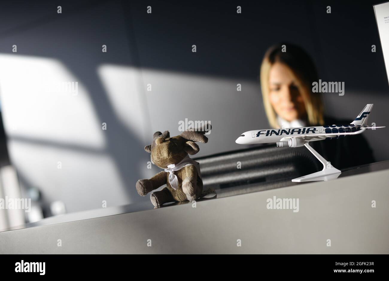 Aeroporto Lyon Saint Exupery (Francia centro-orientale): Biondo indirizzo alla reception della compagnia aerea finlandese Finnair. Giocattolo morbido e velivolo modello Foto Stock