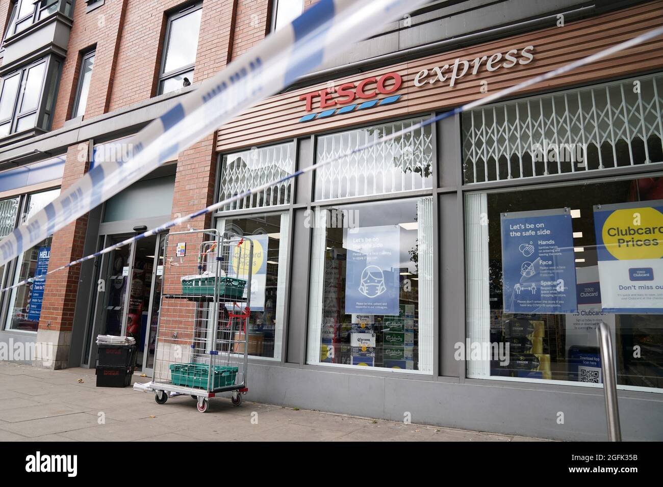 Nastro di polizia blocca l'ingresso a Tesco Express su Fulham Palace Road, West London, che è stato chiuso e una scena criminale messa in atto dopo che un uomo è stato arrestato per sospetto di contaminare il cibo con una siringa. Mercoledì sera la polizia è stata chiamata ad un uomo che gridava abusi alle persone in strada e tre supermercati Tesco Express, Little Waitrose e Sainsbury's Local - sono stati chiusi per indagini. Data foto: Giovedì 26 agosto 2021. Foto Stock
