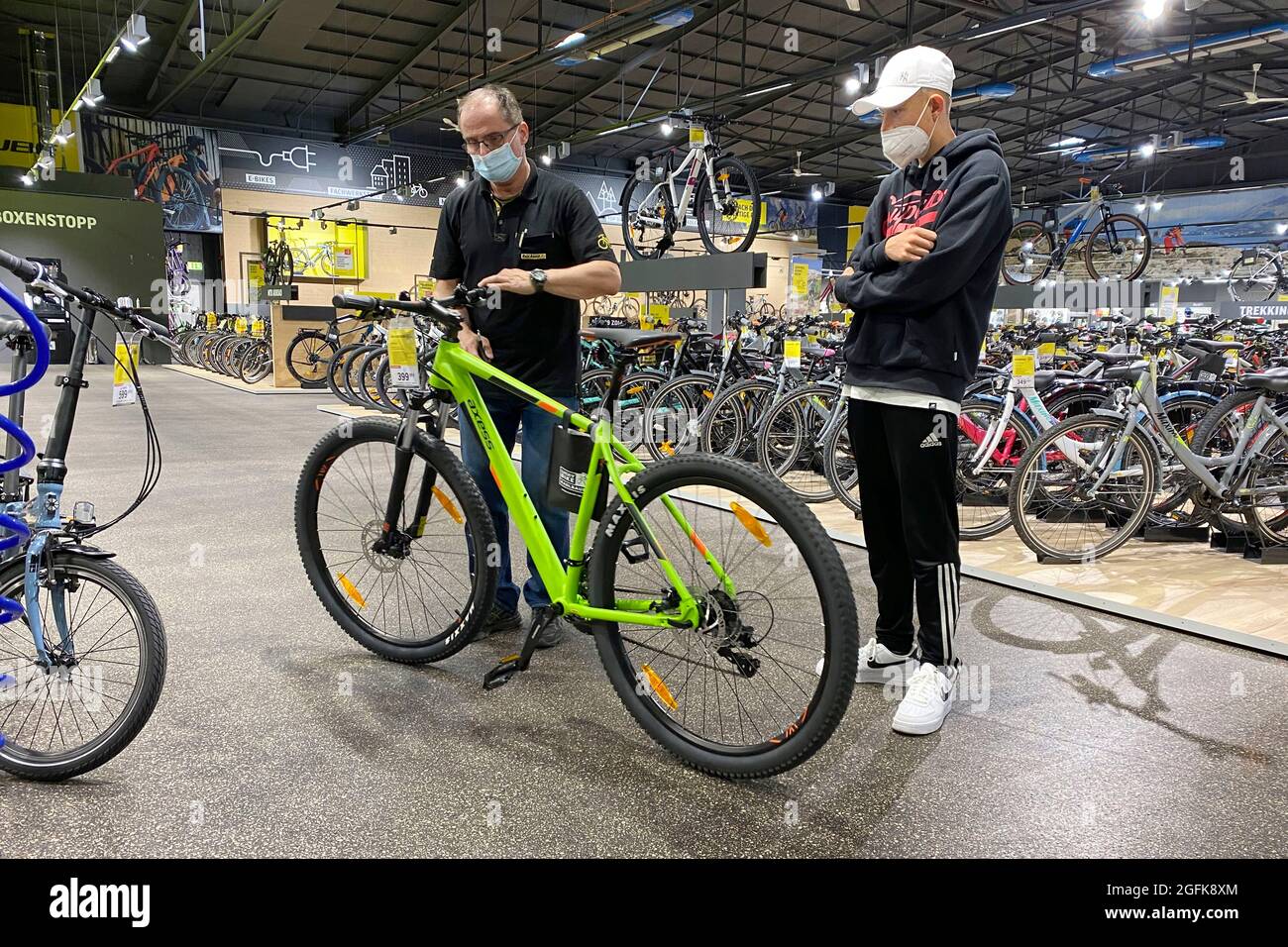 Monaco di Baviera, Germania. 26 agosto 2021. Comprare una bicicletta nella  zona pandemica. Un adolescente che acquista una bicicletta in un negozio  specializzato a due ruote. Un venditore consiglia il giovane cliente