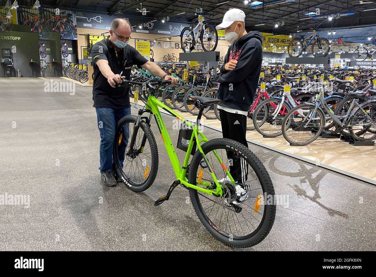 Monaco di Baviera, Germania. 26 agosto 2021. Comprare una bicicletta nella  zona pandemica. Un adolescente che acquista una bicicletta in un negozio  specializzato a due ruote. Un venditore consiglia il giovane cliente
