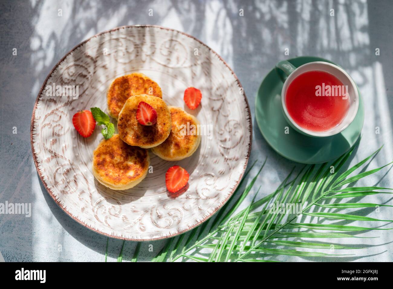 al mattino vi attende una prima colazione con pancake al formaggio e una tazza di tè alla luce del sole nel ristorante Foto Stock