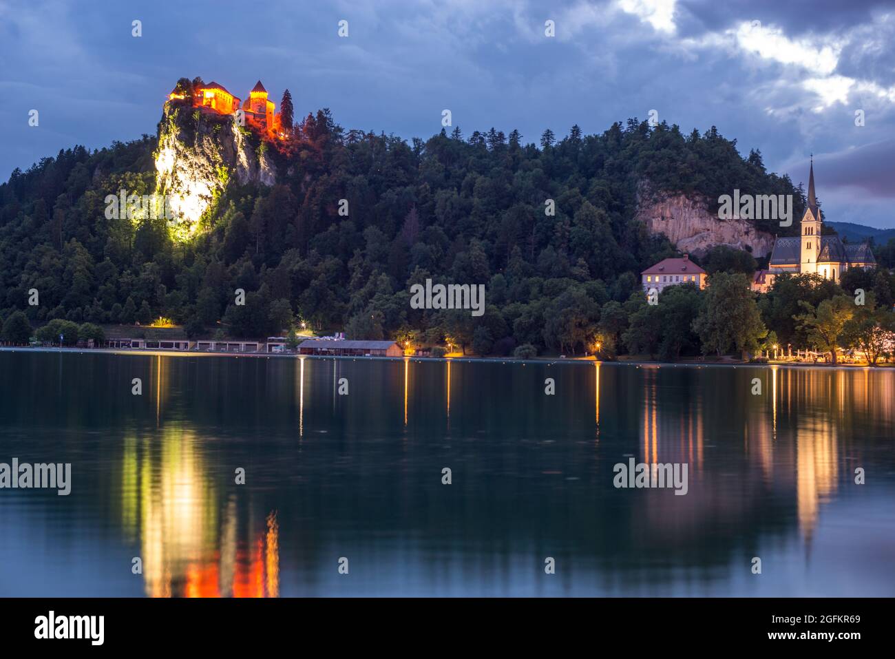 Il castello di Bled è illuminato durante l'ora blu e si affaccia sul lago Foto Stock