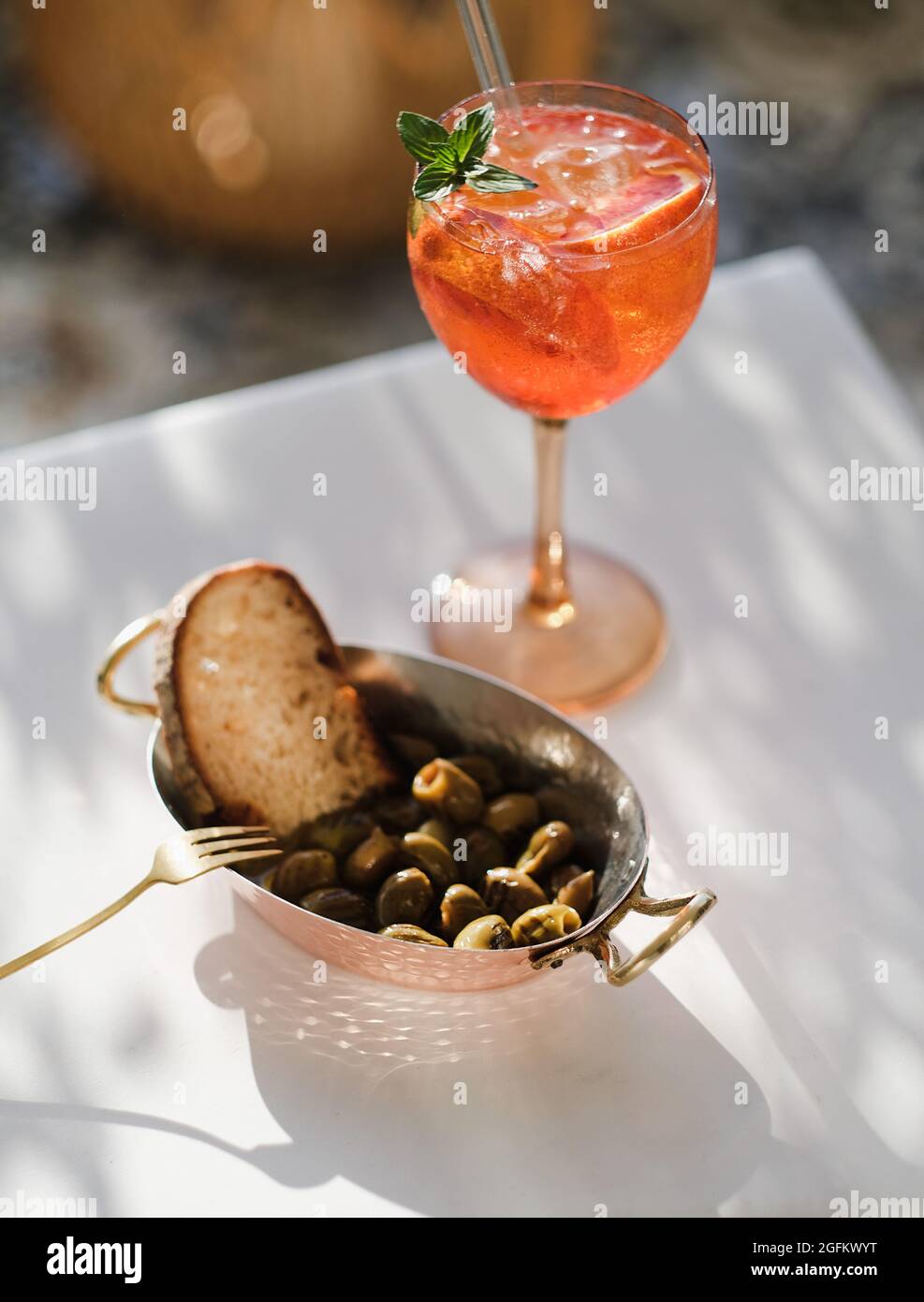 Olive mediterranee alla griglia e bicchiere di cocktail aperol spritz Foto Stock