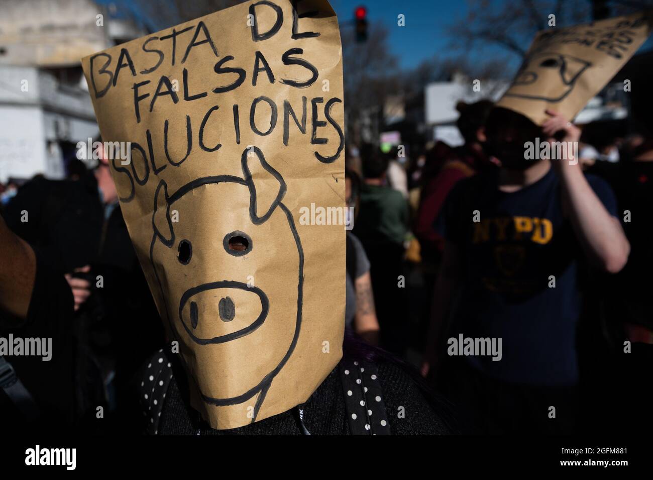 Buenos Aires, Argentina. 25 ago 2021. Un protesto è visto indossare una maschera di carta che dice "Stop False Solutions" durante una protesta presso l'ambasciata cinese in Argentina. Partiti politici di sinistra e organizzazioni ambientali protestano contro l'ambasciata cinese in Argentina contro l'accordo sul commercio di carne suina tra i due paesi, che propone l'installazione di aziende industriali per la produzione di suini. (Foto di Manuel Cortina/SOPA Images/Sipa USA) Credit: Sipa USA/Alamy Live News Foto Stock