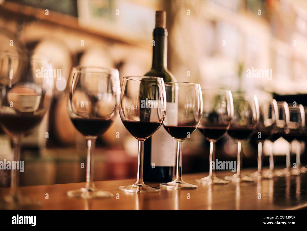 Bottiglia di vino con bicchieri di vino rosso su tavola di legno Foto Stock