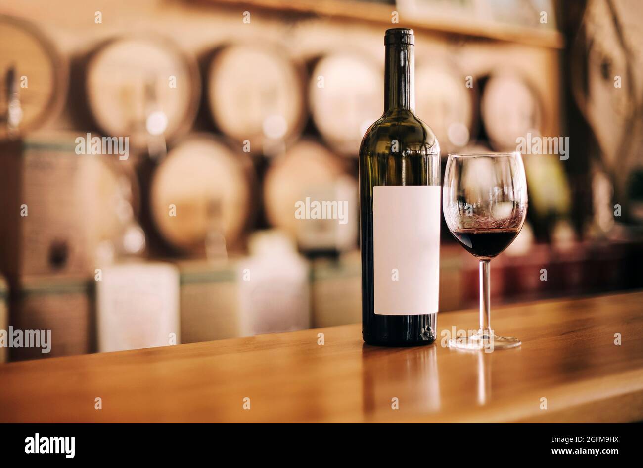 Bottiglia di vino con bicchiere di vino rosso su tavola di legno Foto Stock