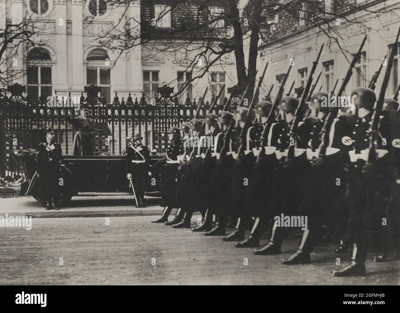 Hitler che dà il saluto nazista mentre osserva le truppe SS che marciavano oltre Foto Stock