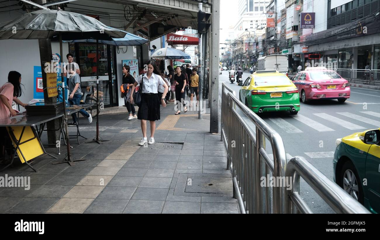 School Girl Walking su Charoen Krung Road aka New Road Bangkok Thailandia Foto Stock