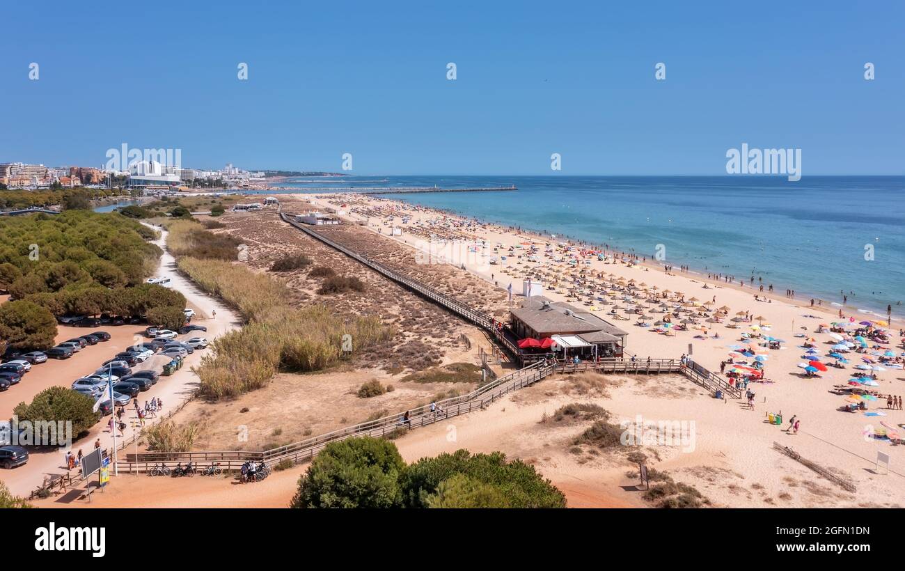 Vista aerea della lussuosa spiaggia di Falesia a Vilamoura. Con i turisti che prendono il sole sui lettini. Porto di Marina con yacht, sullo sfondo. Foto Stock