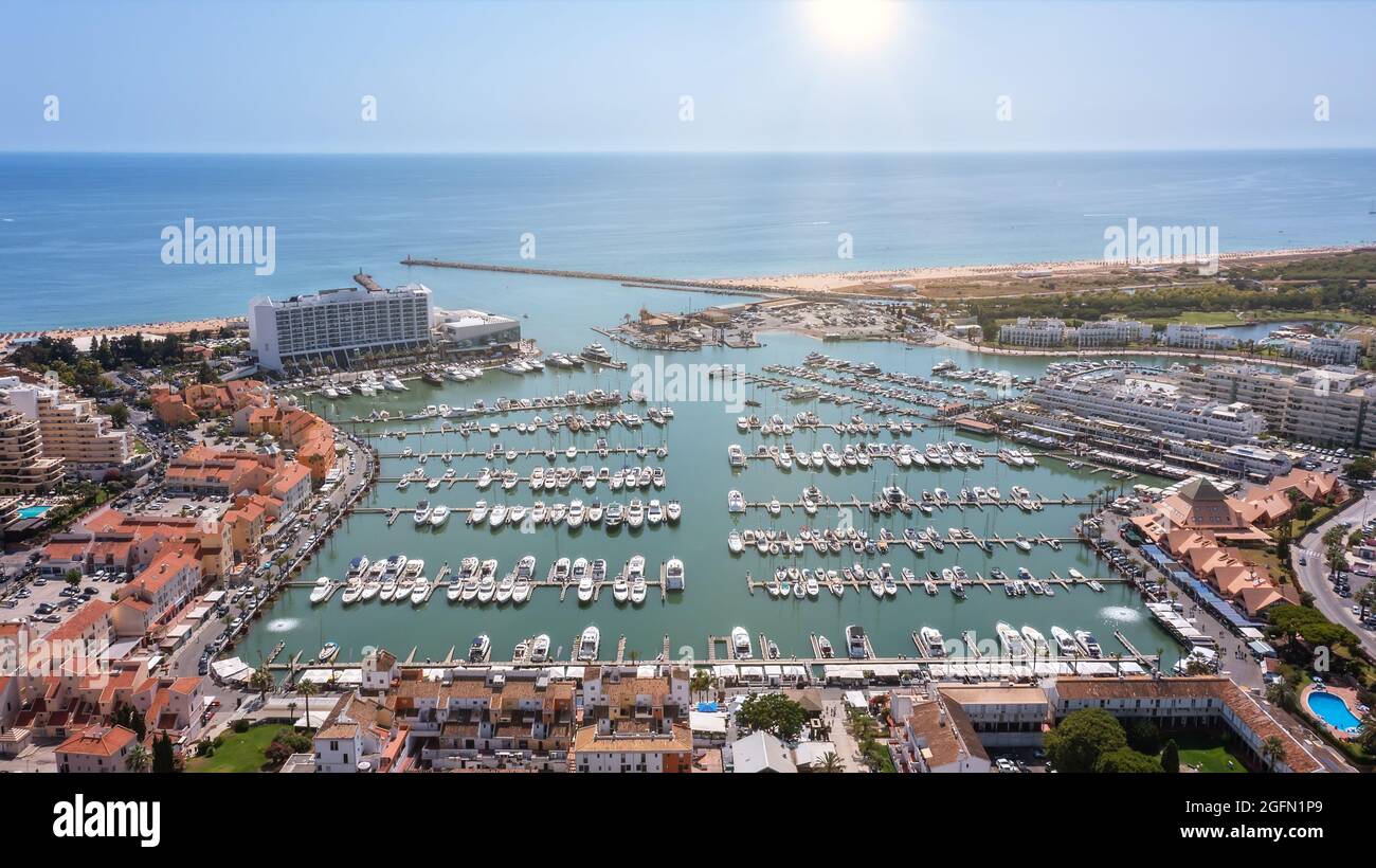 Una vista dal cielo della città turistica portoghese di Vilamoura, con barche a vela e barche ormeggiate nel porto sul molo. Foto Stock