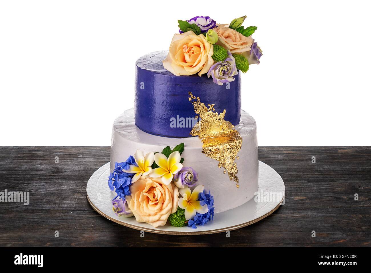 Una bella torta nuziale concettuale fatta di due piani, fiori di rosa, e  gioielli d'oro. Su un tavolo di legno, su sfondo bianco Foto stock - Alamy