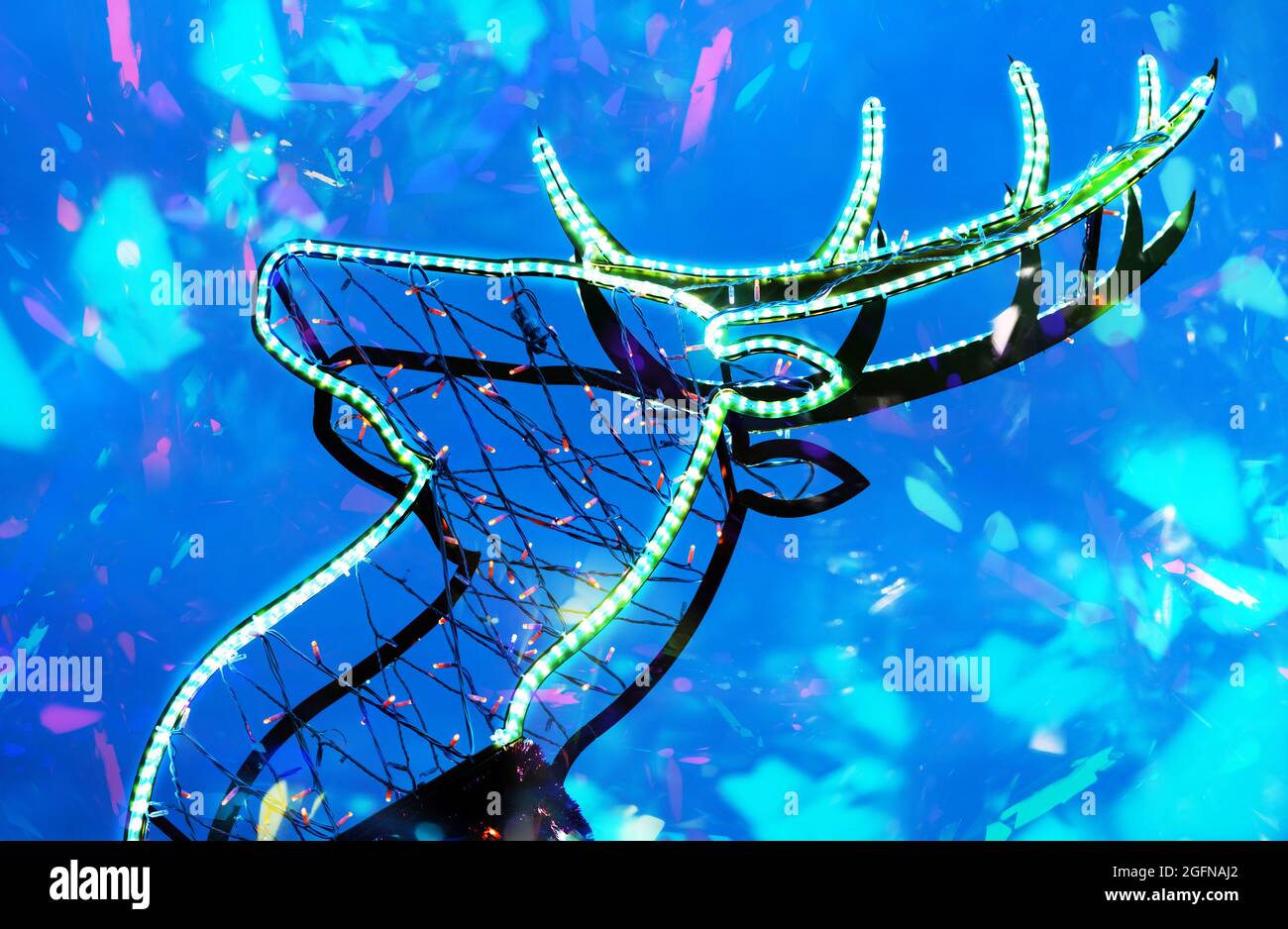 Foto della scultura di cervo che risplende il natale con effetti scintillanti su sfondo blu. Foto Stock