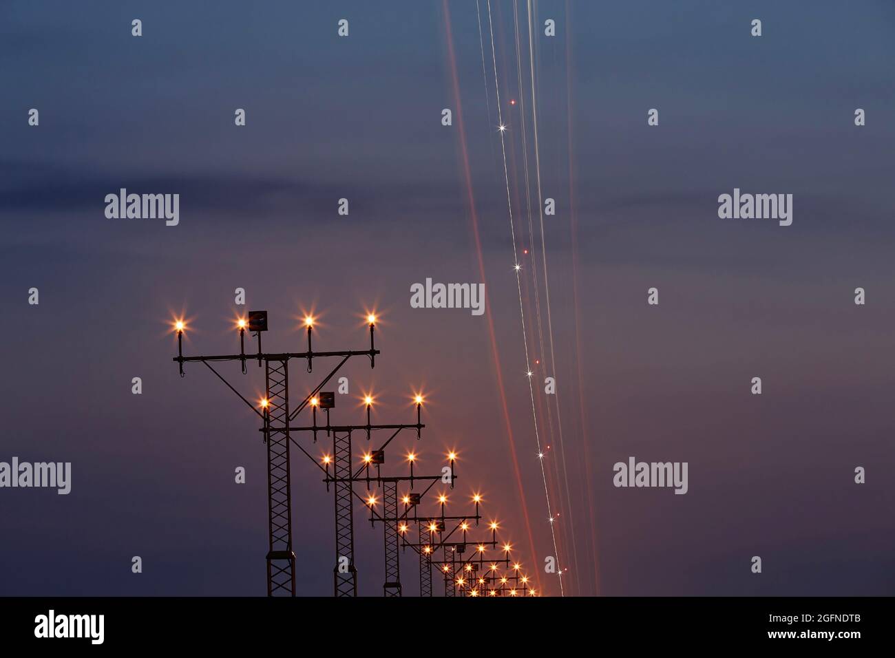 Leggero sentiero di aeroplano durante l'avvicinamento all'aeroporto. Scena notturna con luci di atterraggio. Foto Stock