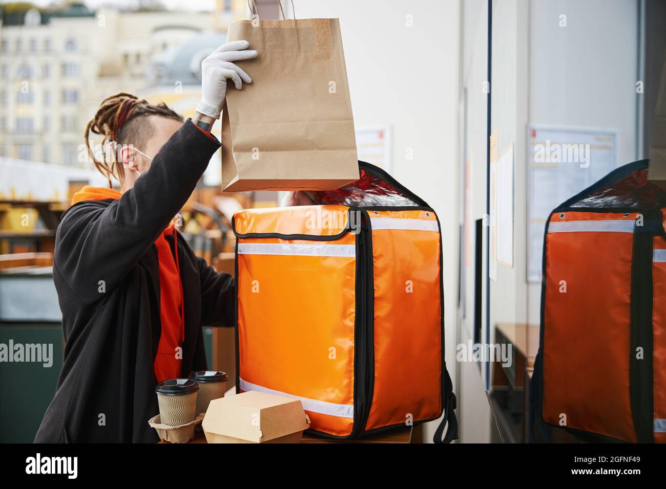 Lavoratore professionale che confezionano cibo per la consegna espressa Foto Stock
