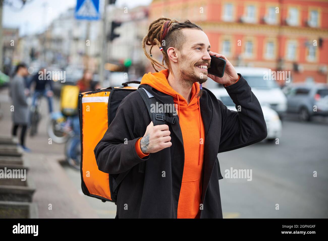 Bel corriere giovane che fa espresso il trasferimento di cibo Foto Stock