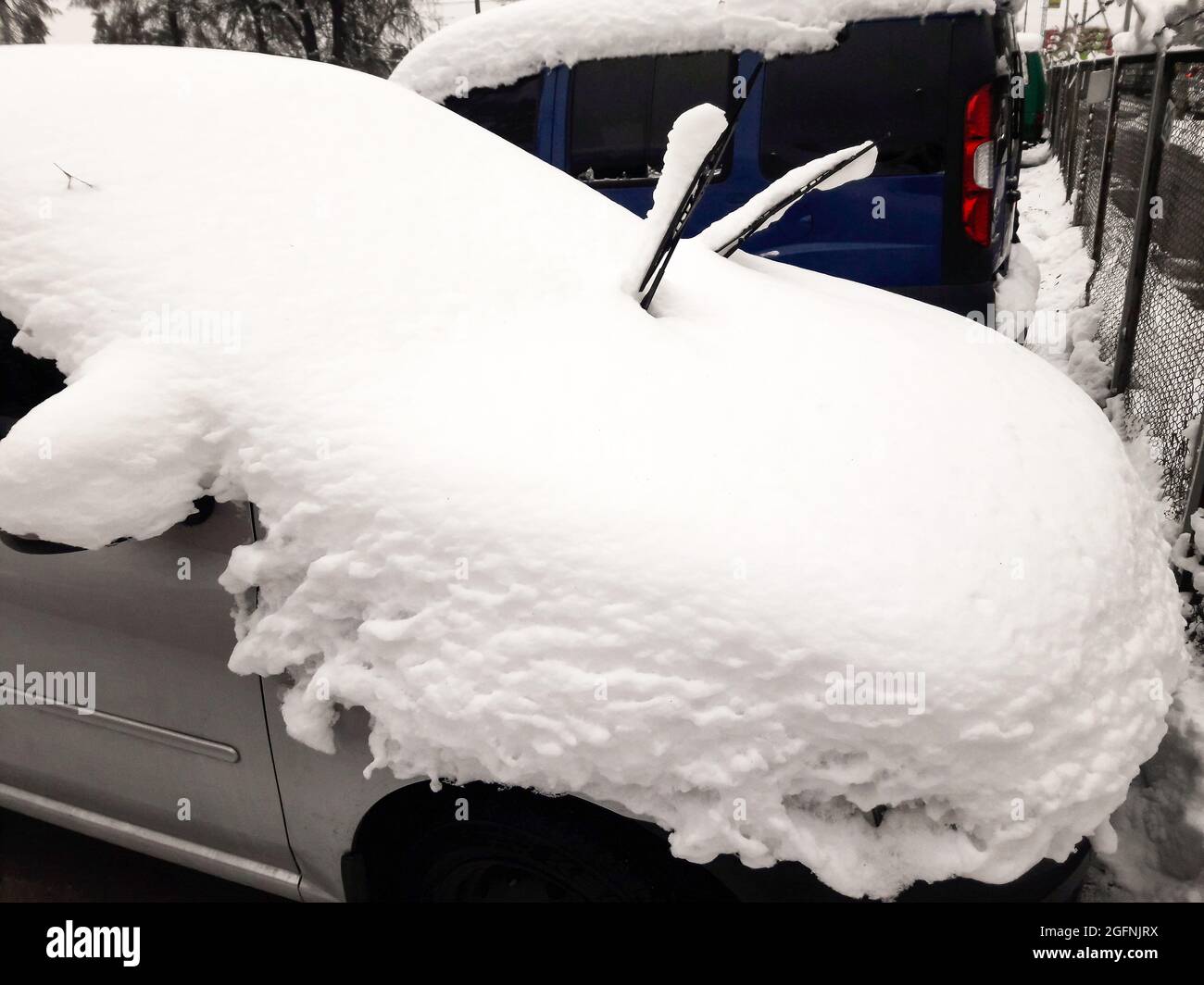 Un'autovettura color argento parcheggiata su un spesso strato di neve sul tetto Foto Stock