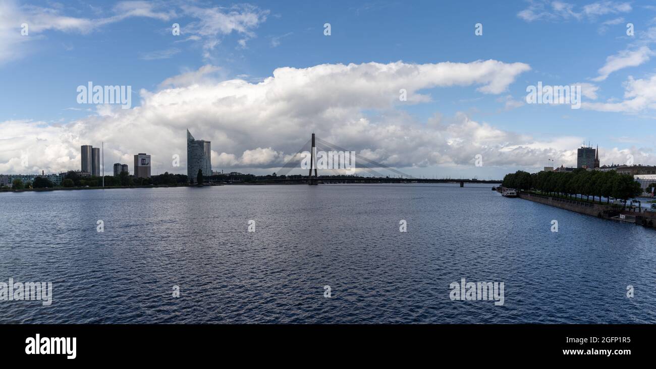 Riga, Lettonia - 19 Agosto, 2021: Il fiume Daugava e Akmens tilts Bridge con lo skyline di riga sullo sfondo Foto Stock