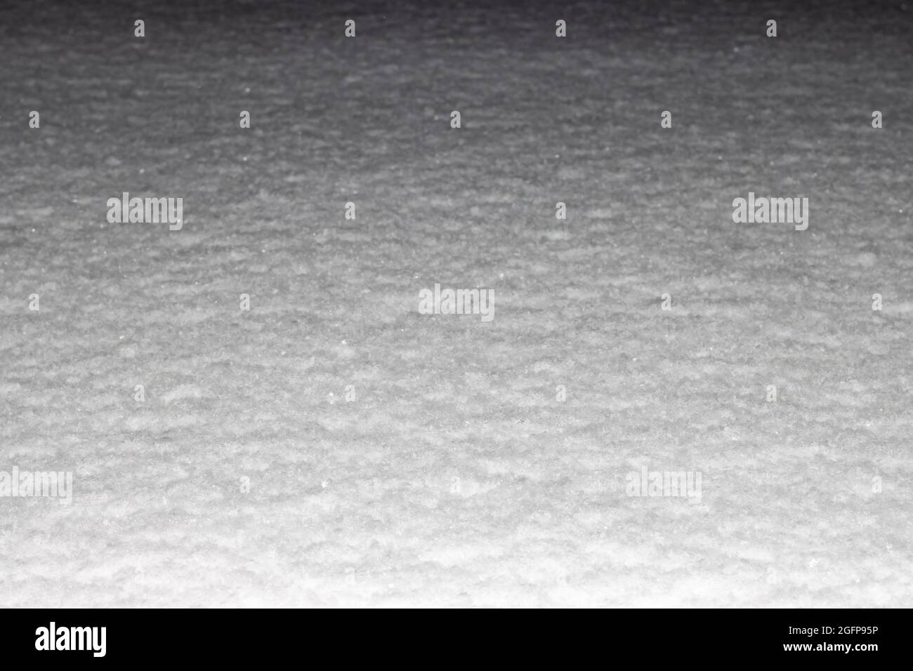 Neve superficie illuminata dal flash di notte, cornice orizzontale, sfondo per il design. Foto Stock