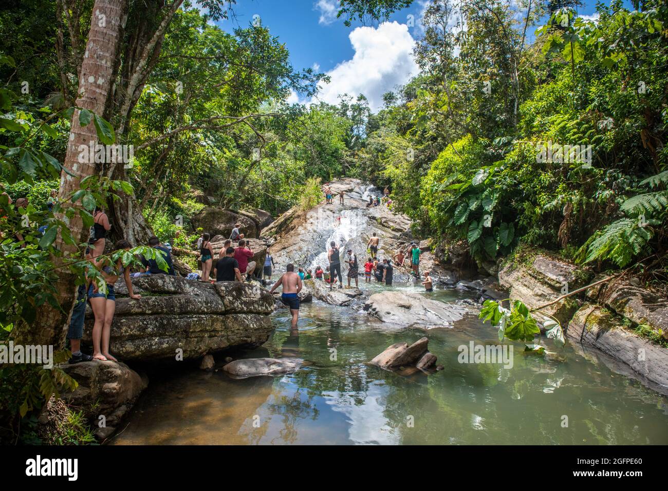 La gente si radunò intorno al fondo di uno scivolo d'acqua naturale - Porto Rico Foto Stock