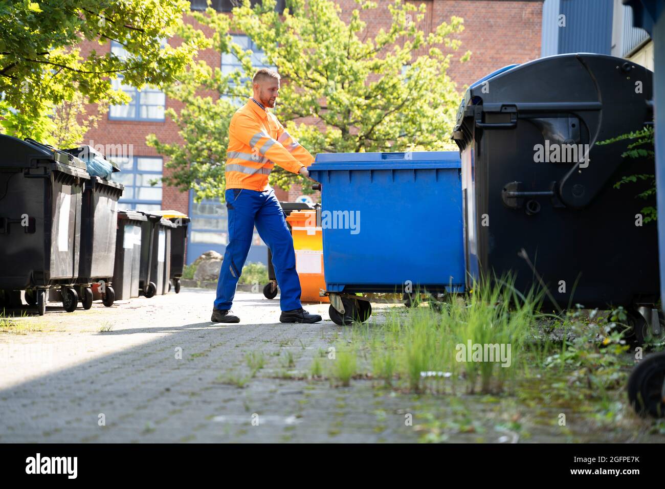 Garbage Removal Man fare Cestino e rifiuti Collection Foto Stock