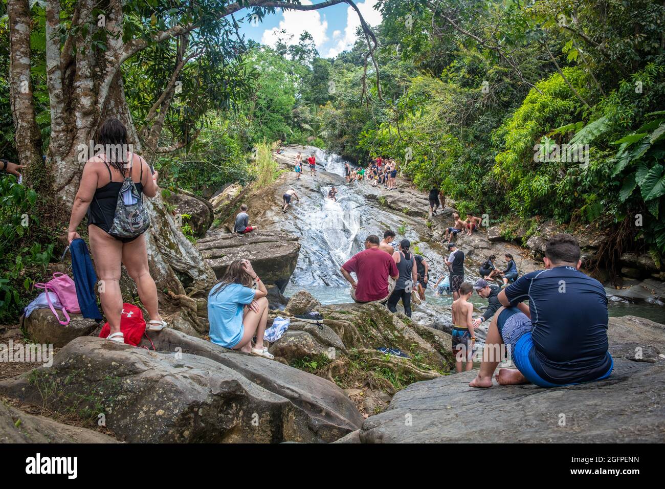 La gente si radunò intorno al fondo di uno scivolo d'acqua naturale - Porto Rico Foto Stock