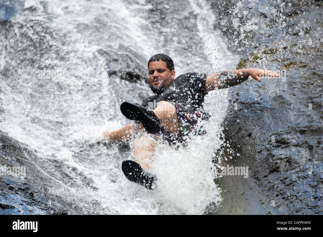 Un uomo che scende da uno scivolo d'acqua naturale - Porto Rico Foto Stock