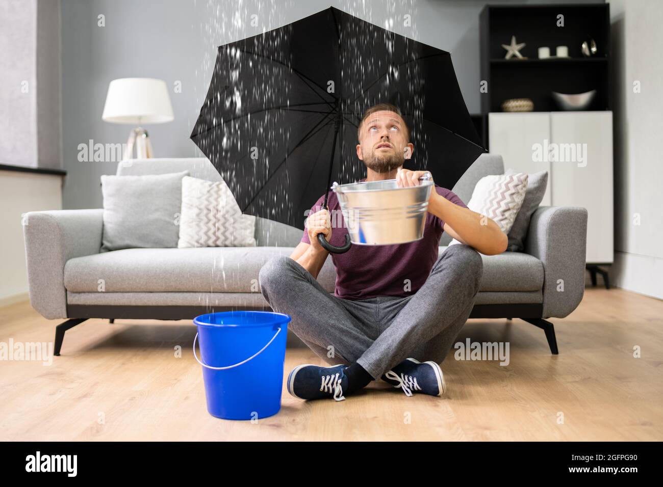 Perdita di emergenza in casa o appartamento. Acqua che cade dal soffitto Foto Stock