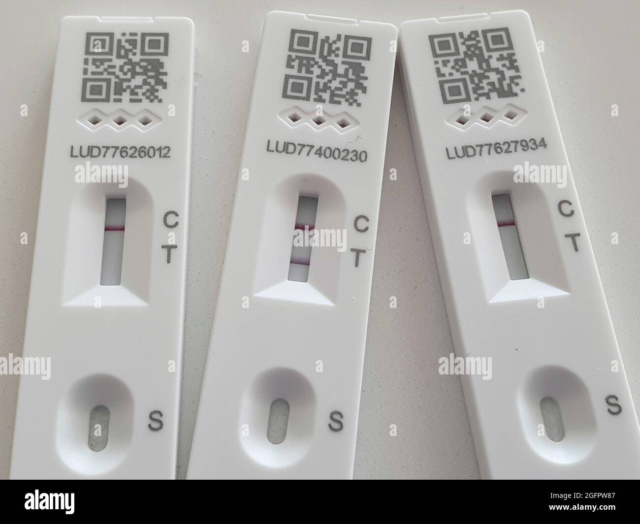 Sussex, UK, 26 agosto 2021: Un test di flusso laterale positivo mostra una doppia linea distinta che conferma la presenza del coronavirus sul campione di tampone. Due prove di flusso laterale negativo mostrano solo una linea singola a C per il controllo. Con oltre 38,000 nuovi test positivi registrati nelle 24 ore precedenti, i casi di Covid-19 sono di nuovo in aumento. Anna Watson/Alamy Live News Foto Stock